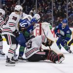 
              Vancouver Canucks' Elias Pettersson, back right, of Sweden, is stopped by Chicago Blackhawks goalie Marc-Andre Fleury (29) as Vancouver's Kyle Burroughs (44) digs for the puck while Chicago's Connor Murphy, back center, Brandon Hagel (38) and Dylan Strome (17) defend during the second period of an NHL hockey game in Vancouver, British Columbia, Sunday, Nov. 21, 2021. (Darryl Dyck/The Canadian Press via AP)
            