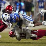 
              Duke wide receiver Jontavis Robertson (1) is tackled by Louisville defensive back Qwynnterrio Cole (12) and defensive back Chandler Jones during the second half of an NCAA college football game in Durham, N.C., Thursday, Nov. 18, 2021. (AP Photo/Gerry Broome)
            