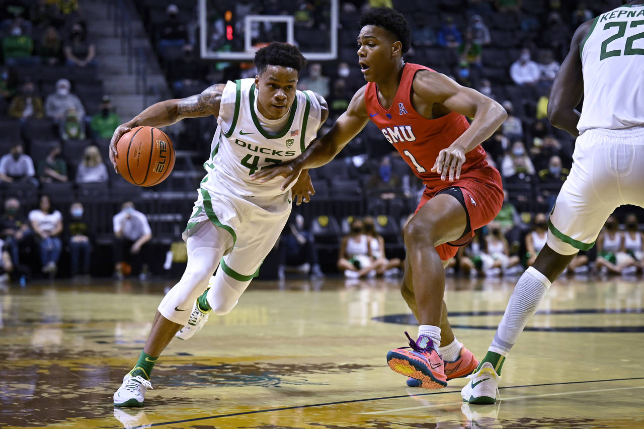 Oregon guard Jacob Young (42) drives against SMU guard Zhuric Phelps (1) during the first half of a...