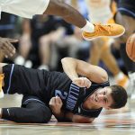 
              Villanova's Collin Gillespie (2) falls to the ground while Tennessee's Victor Bailey Jr. (12) leaps over him while chasing a loose ball in the first half of an NCAA college basketball game, Saturday, Nov. 20, 2021, in Uncasville, Conn. (AP Photo/Jessica Hill)
            