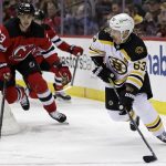 
              Boston Bruins center Brad Marchand (63) looks to pass in front of New Jersey Devils defenseman Ryan Graves during the second period of an NHL hockey game Saturday, Nov. 13, 2021, in Newark, N.J. (AP Photo/Adam Hunger)
            