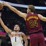 
              Phoenix Suns' Devin Booker (1) shoots against Cleveland Cavaliers' Lauri Markkanen (24) during the first half of an NBA basketball game Wednesday, Nov. 24, 2021, in Cleveland. (AP Photo/Tony Dejak)
            
