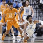 
              North Carolina's R.J. Davis (4) falls to the floor as Tennessee's Santiago Vescovi (25) defends in the first half of an NCAA college basketball game, Sunday, Nov. 21, 2021, in Uncasville, Conn. (AP Photo/Jessica Hill)
            