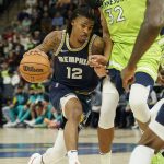 
              Memphis Grizzlies guard Ja Morant drives past Minnesota Timberwolves center Karl-Anthony Towns during the first half of an NBA basketball game Saturday, Nov. 20, 2021, in Minneapolis. (AP Photo/Craig Lassig)
            