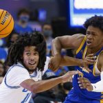 
              UCLA guard Tyger Campbell, left, and Cal State Bakersfield guard David Walker chase the ball during the first half of an NCAA college basketball game Tuesday, Nov. 9, 2021, in Los Angeles. (AP Photo/Ringo H.W. Chiu)
            