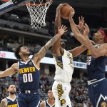 
              Indiana Pacers center Myles Turner, center, pulls in a rebound between Denver Nuggets guard Markus Howard, left, and forward Zeke Nnaji in the second half of an NBA basketball game Wednesday, Nov. 10, 2021, in Denver. (AP Photo/David Zalubowski)
            