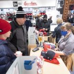 
              Lucas Foote, left, and Greg Foote, center, check out at the opening of the Cleveland Guardians team store in Cleveland, Friday, Nov. 19, 2021, in Cleveland. It's Day One for the Guardians, who will put caps, jerseys and other merchandise on sale to the public for the first time since dropping the name Indians, the franchise's identity since 1915. (AP Photo/Ken Blaze)
            