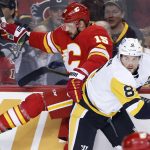 
              Pittsburgh Penguins' Brian Dumoulin, right, hits Calgary Flames' Brad Richardson during the first period of an NHL hockey game, Monday, Nov. 29, 2021 in Calgary, Alberta. (Larry MacDougal/The Canadian Press via AP)
            