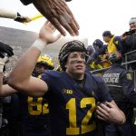 
              Michigan quarterback Cade McNamara greets fans as he exits the field after the second half of an NCAA college football game against Ohio State, Saturday, Nov. 27, 2021, in Ann Arbor, Mich. (AP Photo/Carlos Osorio)
            