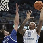 
              North Carolina forward Armando Bacot (5) shoots while North Carolina Asheville forward Drew Pember defends during the first half of an NCAA college basketball game in Chapel Hill, N.C., Tuesday, Nov. 23, 2021. (AP Photo/Gerry Broome)
            