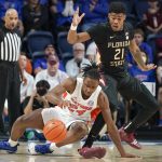 
              Florida guard Phlandrous Fleming Jr., left, goes after a loose ball in front of Florida State guard Cam'Ron Fletcher (21) during the first half of an NCAA college basketball game, Sunday, Nov. 14, 2021, in Gainesville, Fla. (AP Photo/John Raoux)
            