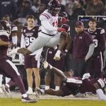 
              Mississippi wide receiver Dontario Drummond (11) leaps over a fallen Mississippi defender for a first down during the first half of an NCAA college football game, Thursday, Nov. 25, 2021, in Starkville, Miss. (AP Photo/Rogelio V. Solis)
            