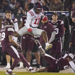 
              Mississippi wide receiver Dontario Drummond (11) leaps over fallen Mississippi safety Jalen Green for a first down during the first half of an NCAA college football game Thursday, Nov. 25, 2021, in Starkville, Miss. (AP Photo/Rogelio V. Solis)
            