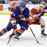 
              New York Islanders center Mathew Barzal (13) controls the puck past Calgary Flames defenseman Oliver Kylington (58) in the second period of an NHL hockey game Saturday, Nov. 20, 2021, in Elmont, N.Y. (AP Photo/Adam Hunger)
            