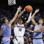 
              Gonzaga guard Hunter Sallis, center, shoots between Lewis-Clark State guard Sam Stockton, left, and forward Kevin Baker during the second half of a college basketball exhibition game, Friday, Nov. 5, 2021, in Spokane, Wash. (AP Photo/Young Kwak)
            