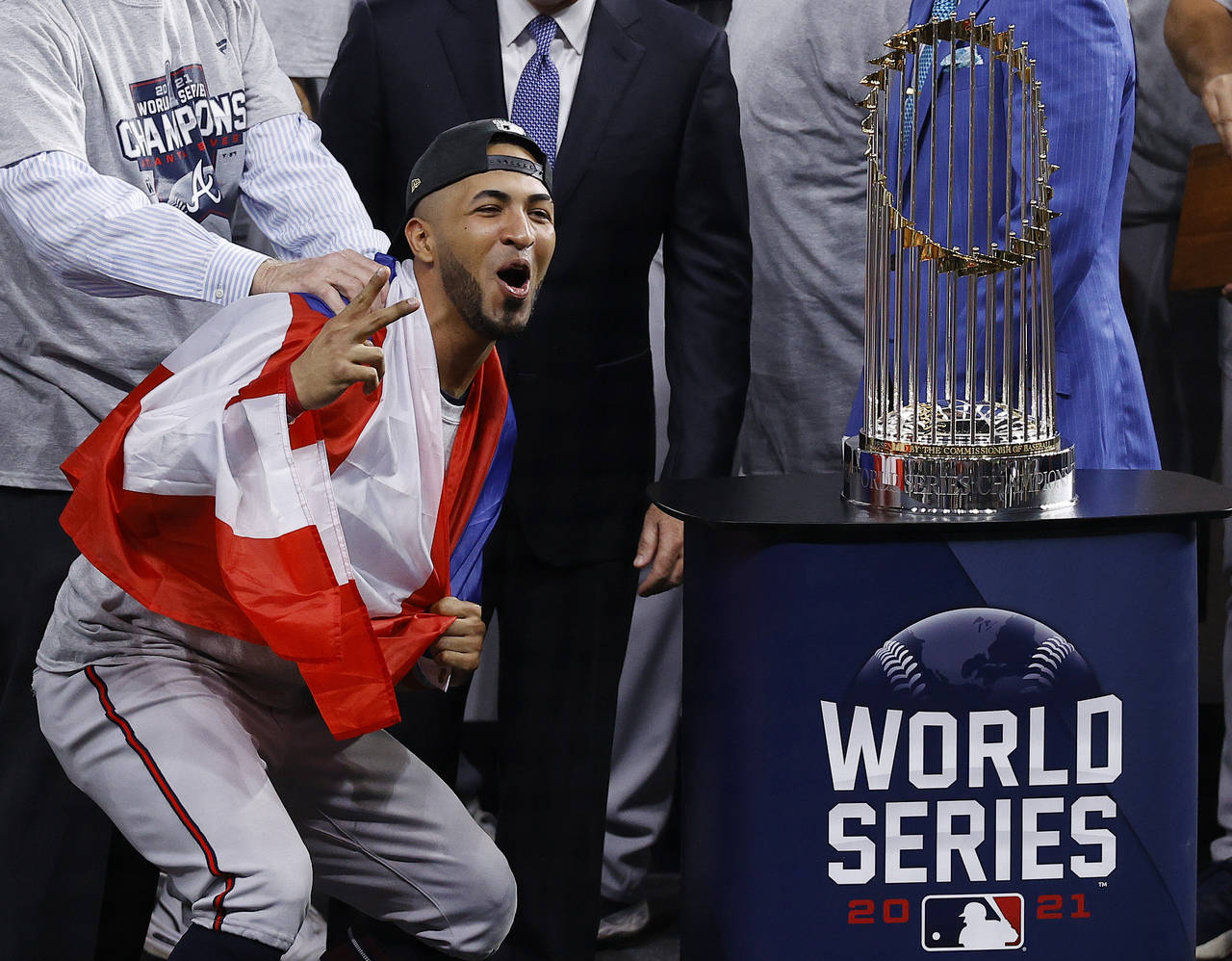 Atlanta Braves left fielder Eddie Rosario stands next to the trophy after the team's win in the Wor...