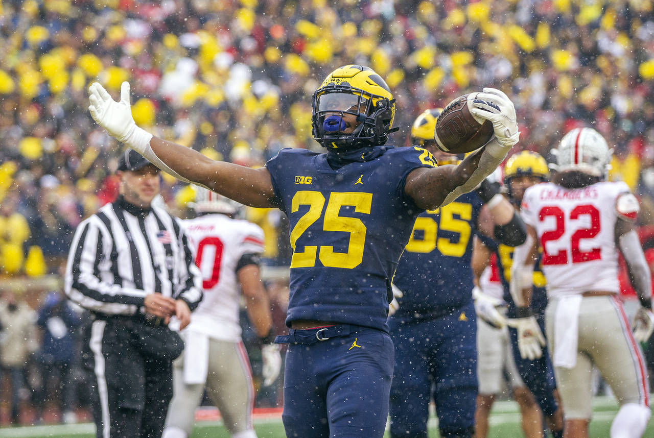 Michigan running back Hassan Haskins (25) celebrates a touchdown in the fourth quarter of an NCAA c...