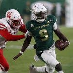 
              South Florida quarterback Timmy McClain scrambles while being pursued by Houston's Deontay Anderson during the first half of an NCAA college football game Saturday, Nov. 6, 2021, in Tampa, Fla. (AP Photo/Scott Audette)
            