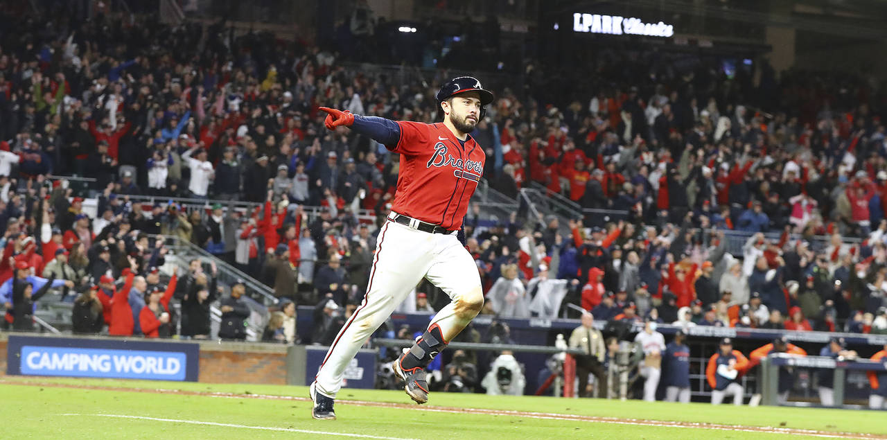 Atlanta Braves' Travis d'Arnaud points at the dugout while rounding the bases on his solo home run ...