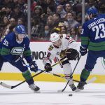 
              Vancouver Canucks' Oliver Ekman-Larsson (23), of Sweden, checks Chicago Blackhawks' Alex DeBrincat (12) in front of Canucks' Bo Horvat (53) during first-period NHL hockey game action in Vancouver, British Columbia, Sunday, Nov. 21, 2021. (Darryl Dyck/The Canadian Press via AP)
            