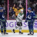 
              Vancouver Canucks' J.T. Miller (9) and Bo Horvat (53) celebrate Miller's second goal as Dallas Stars' Roope Hintz, of Finland, skates past them during the third period of an NHL hockey game in Vancouver, British Columbia, Sunday, Nov. 7, 2021. (Darryl Dyck/The Canadian Press via AP)
            