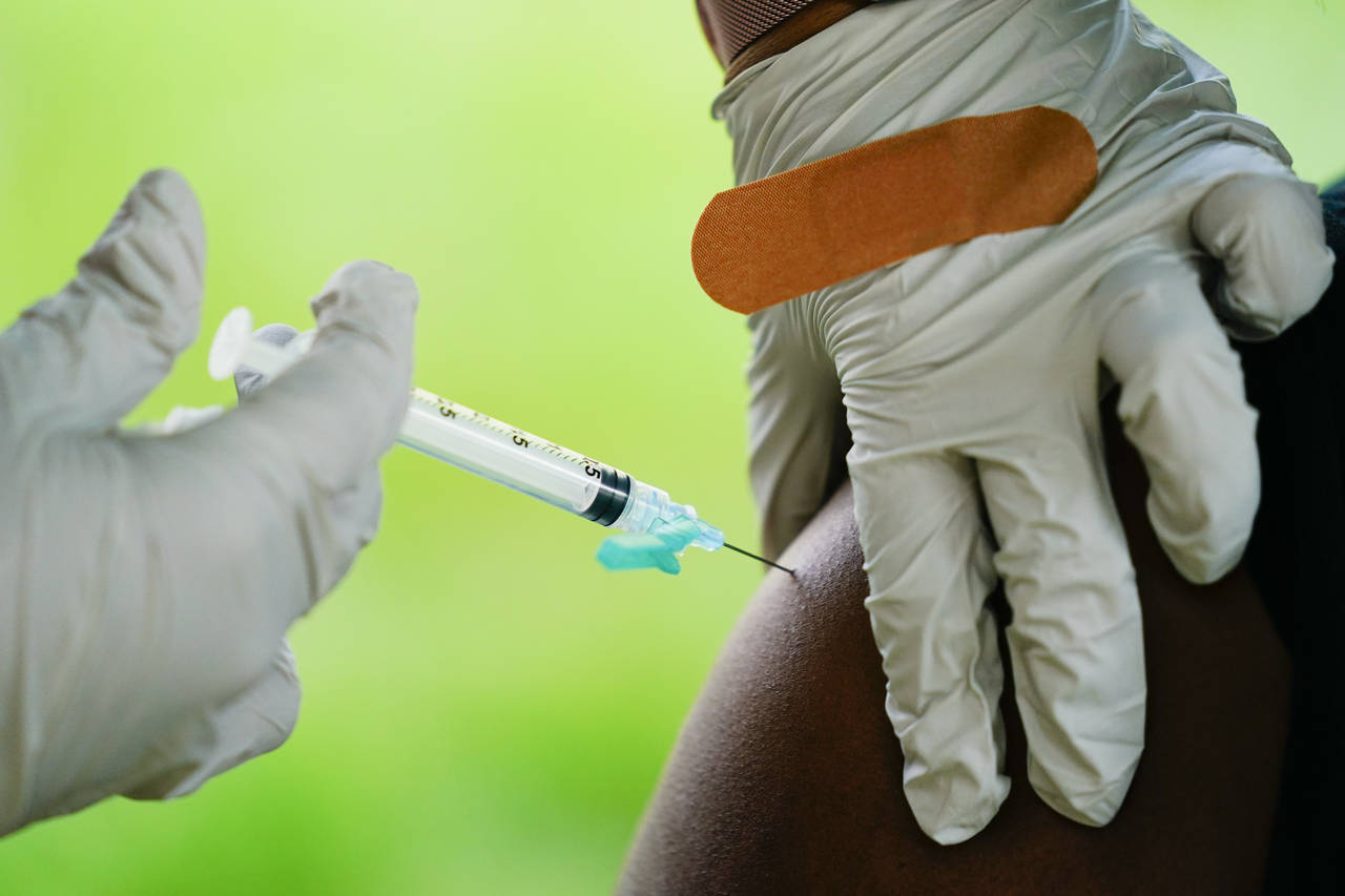FILE - A health worker administers a dose of a Pfizer COVID-19 vaccine at a vaccination clinic in R...