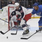 
              Columbus Blue Jackets' Jake Bean (22) battles for the puck against St. Louis Blues' Dakota Joshua (54) during the second period of an NHL hockey game Saturday, Nov. 27, 2021, in St. Louis. (AP Photo/Michael Thomas)
            