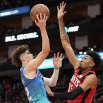 
              Charlotte Hornets guard LaMelo Ball , left, shoots as Houston Rockets center Christian Wood defends during the first half of an NBA basketball game, Saturday, Nov. 27, 2021, in Houston. (AP Photo/Eric Christian Smith)
            