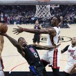
              Los Angeles Clippers guard Eric Bledsoe (12) drives to the basket between Miami Heat center Bam Adebayo, center right, and guard Gabe Vincent (2) during the first half of an NBA basketball game Thursday, Nov. 11, 2021, in Los Angeles. (AP Photo/Marcio Jose Sanchez)
            