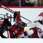 
              Columbus Blue Jackets defenseman Adam Boqvist (27) collides with Arizona Coyotes goalie Scott Wedgewood (31) during the first period of an NHL hockey game Thursday, Nov. 18, 2021, in Glendale, Ariz. (AP Photo/Ross D. Franklin)
            
