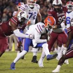 
              Florida quarterback Emory Jones (5) runs with the ball as South Carolina linebacker Brad Johnson, left, reaches for him during the first half of an NCAA college football game Saturday, Nov. 6, 2021, in Columbia, S.C. (AP Photo/Sean Rayford)
            