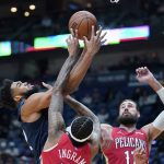 
              Minnesota Timberwolves center Karl-Anthony Towns (32) goes to the basket against New Orleans Pelicans forward Brandon Ingram and center Jonas Valanciunas in the first half of an NBA basketball game in New Orleans, Monday, Nov. 22, 2021. (AP Photo/Gerald Herbert)
            