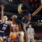 
              Maryland's Angel Reese, center, looks to shoot as she is sandwiched between Villanova's Maddy Siegrist, left, and Christina Dalce during the first half of an NCAA college basketball game on Friday, Nov. 12, 2021, in College Park, Md. (AP Photo/Gail Burton)
            