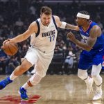 
              Dallas Mavericks guard Luka Doncic (77) gets past Los Angeles Clippers guard Eric Bledsoe (12) during the first half of an NBA basketball game Tuesday, Nov. 23, 2021, in Los Angeles. (AP Photo/John McCoy)
            