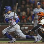 
              Los Angeles Dodgers' Mookie Betts, left, hits a single in front of San Francisco Giants catcher Buster Posey during the eighth inning of Game 5 of a baseball National League Division Series Thursday, Oct. 14, 2021, in San Francisco. (AP Photo/John Hefti)
            