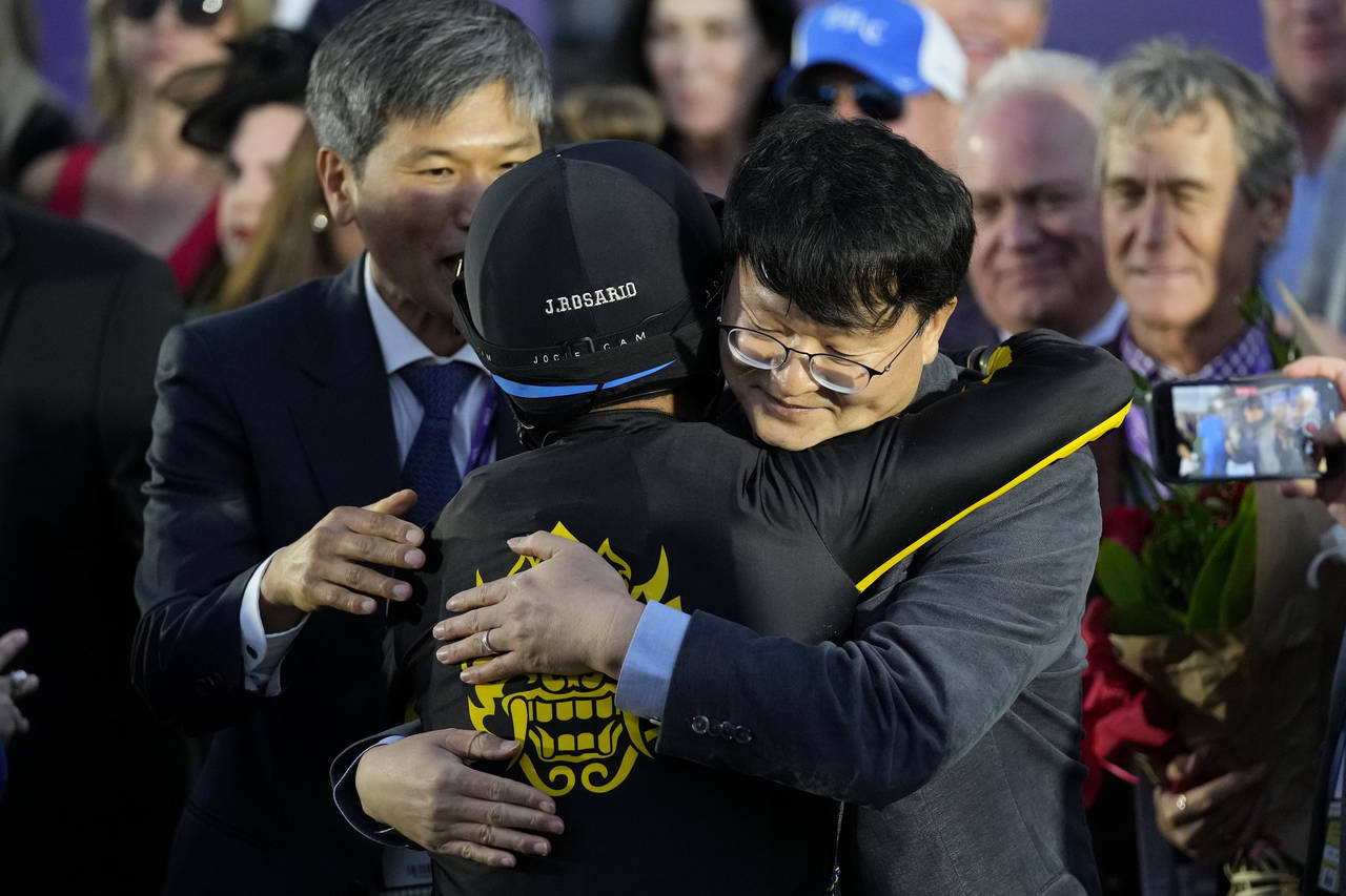 Joel Rosario, center, is congratulated by Lee Jinwoo, senior manager from Korea Racing Authority, r...