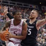 
              Arkansas' Au'Diese Toney (5) looks to pass under pressure from Cincinnati's Mason Madsen during the first half of an NCAA college basketball game Tuesday, Nov. 23, 2021, in Kansas City, Mo. (AP Photo/Charlie Riedel)
            