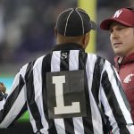 
              Washington State acting head coach Jake Dickert, right, talks to an official during the second half of an NCAA college football game against Washington, Friday, Nov. 26, 2021, in Seattle. (AP Photo/Ted S. Warren)
            