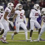 
              Washington State defensive back Derrick Langford (5) celebrates with teammates after he intercepted a pass against Washington during the second half of an NCAA college football game, Friday, Nov. 26, 2021, in Seattle. (AP Photo/Ted S. Warren)
            