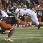 
              Toledo's Bryant Koback, right, is stopped by Bowling Green's Trent Simms as Toledo's Devin Maddox (8) tries to block during the first half of an NCAA college football game Wednesday, Nov. 10, 2021, in Bowling Green, Ohio. (J.D. Pooley/Sentinel-Tribune via AP)
            