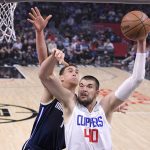 
              Los Angeles Clippers center Ivica Zubac, right, shoots as Dallas Mavericks center Dwight Powell defends during the first half of an NBA basketball game Sunday, Nov. 21, 2021, in Los Angeles. (AP Photo/Mark J. Terrill)
            