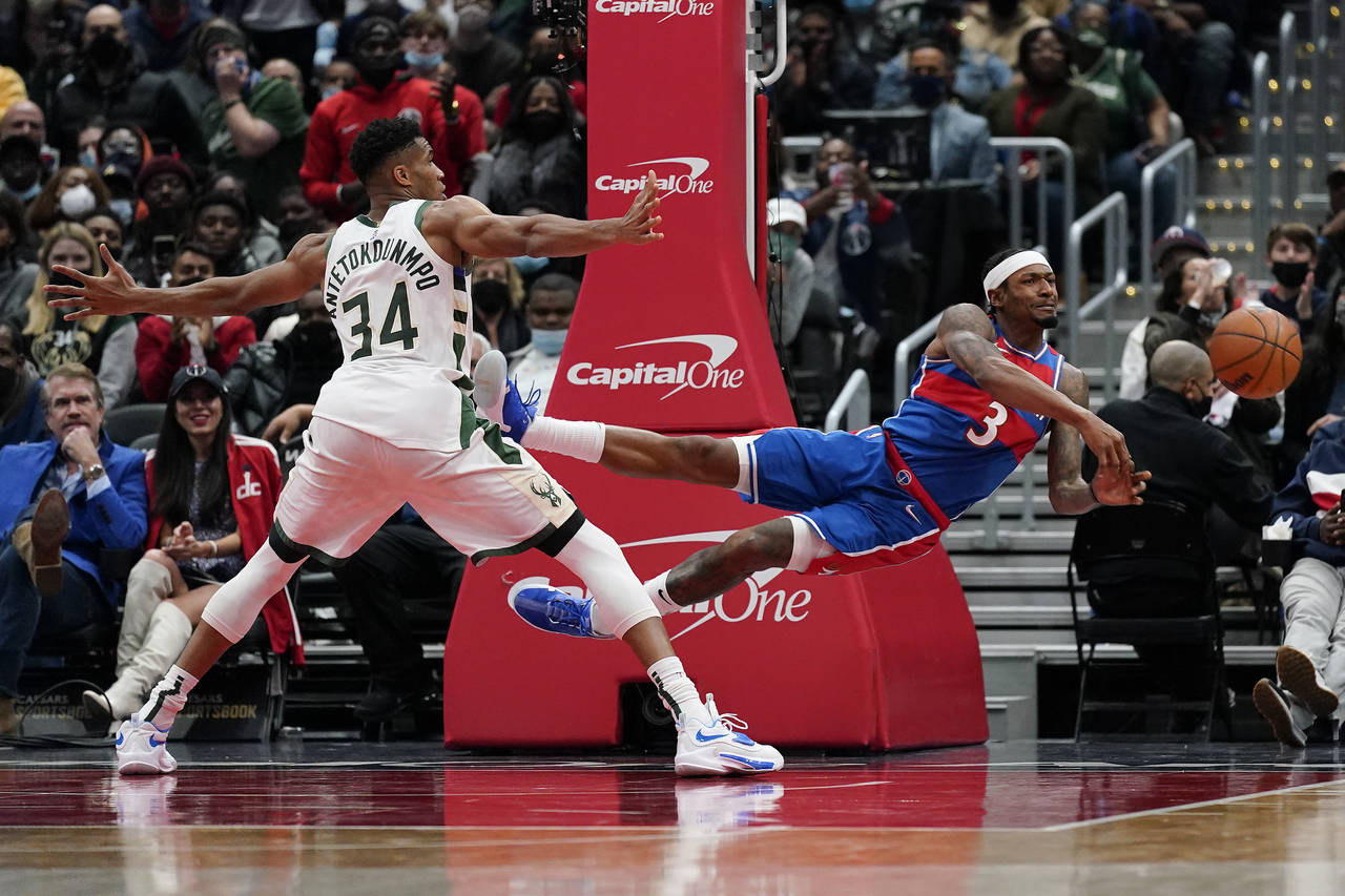 Washington Wizards guard Bradley Beal, right, passes the ball in front of Milwaukee Bucks forward G...