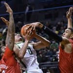 
              Oregon guard Will Richardson (0) is tied up by SMU forward Tristan Clark (25) as SMU forward Marcus Weathers (50) helps on the play during the first half of an NCAA college basketball game Friday, Nov. 12, 2021, in Eugene, Ore. (AP Photo/Andy Nelson)
            