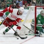 
              Detroit Red Wings center Michael Rasmussen (27) pressures the net as Dallas Stars' Jason Robertson, rear, and goaltender Jake Oettinger (29) defend in the second period of an NHL hockey game in Dallas, Tuesday, Nov. 16, 2021. (AP Photo/Tony Gutierrez)
            
