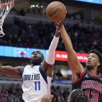 
              Dallas Mavericks forward Tim Hardaway Jr., left, and Chicago Bulls center Tony Bradley reach for a rebound during the first half of an NBA basketball game in Chicago, Wednesday, Nov. 10, 2021. (AP Photo/Nam Y. Huh)
            