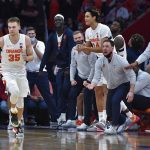 
              Syracuse guard Buddy Boeheim (35) runs back to defend as the bench reacts to him scoring against Indiana during the second overtime of an NCAA college basketball game in Syracuse, N.Y., Tuesday, Nov. 30, 2021. Syracuse beat Indiana 112-110 in double overtime. (AP Photo/Adrian Kraus)
            