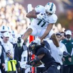
              Michigan State running back Connor Heyward (11) leaps over Purdue safety Marvin Grant (4) during the first half of an NCAA college football game in West Lafayette, Ind., Saturday, Nov. 6, 2021. (AP Photo/Michael Conroy)
            