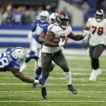 
              Tampa Bay Buccaneers' Leonard Fournette (7) runs past Indianapolis Colts' Bobby Okereke (58) during the second half of an NFL football game, Sunday, Nov. 28, 2021, in Indianapolis. (AP Photo/Michael Conroy)
            