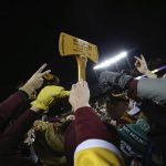 
              Minnesota fans reach up toward Paul Bunyan's Ax after Minnesota defeated Wisconsin in an NCAA college football game Saturday, Nov. 27, 2021, in Minneapolis. (AP Photo/Stacy Bengs)
            