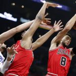 
              Chicago Bulls guard Zach LaVine, right, pulls down a rebound against Los Angeles Clippers center Ivica Zubac (40) and Bulls guard Devon Dotson, center, during the first half of an NBA basketball game Sunday, Nov. 14, 2021, in Los Angeles. (AP Photo/Alex Gallardo)
            